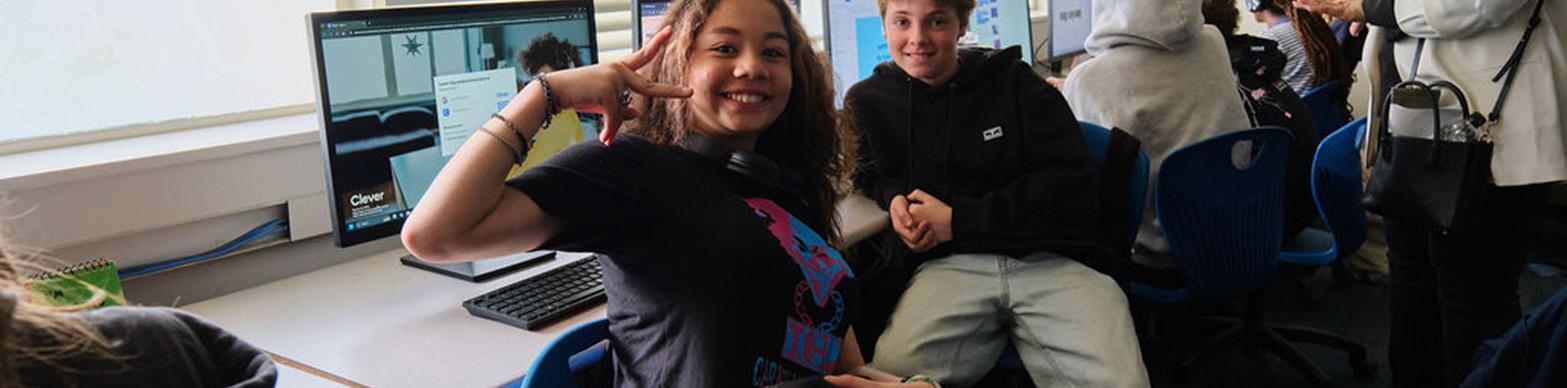 Students pose in front of computer