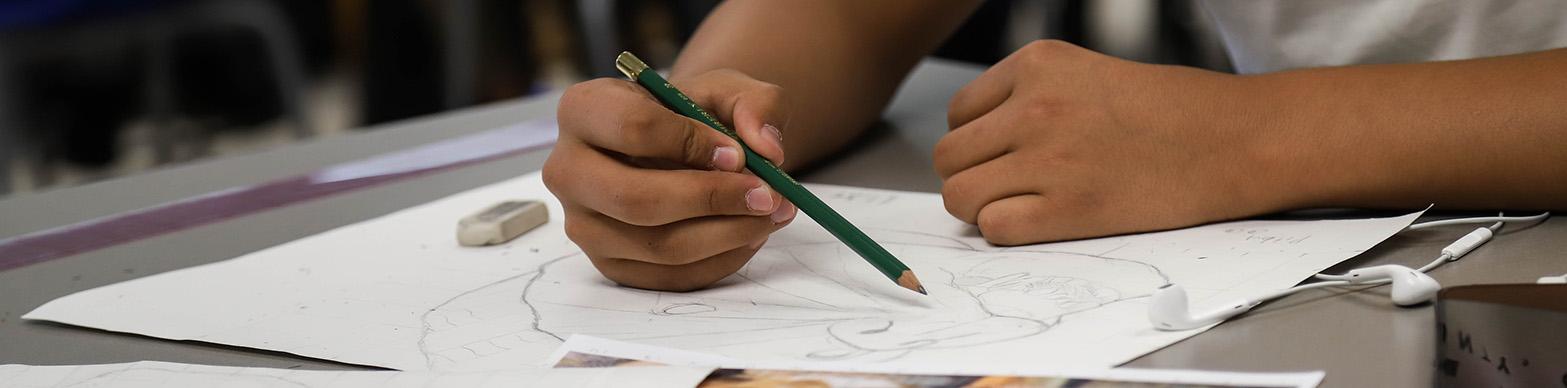 Young Latino boy's hands drawing
