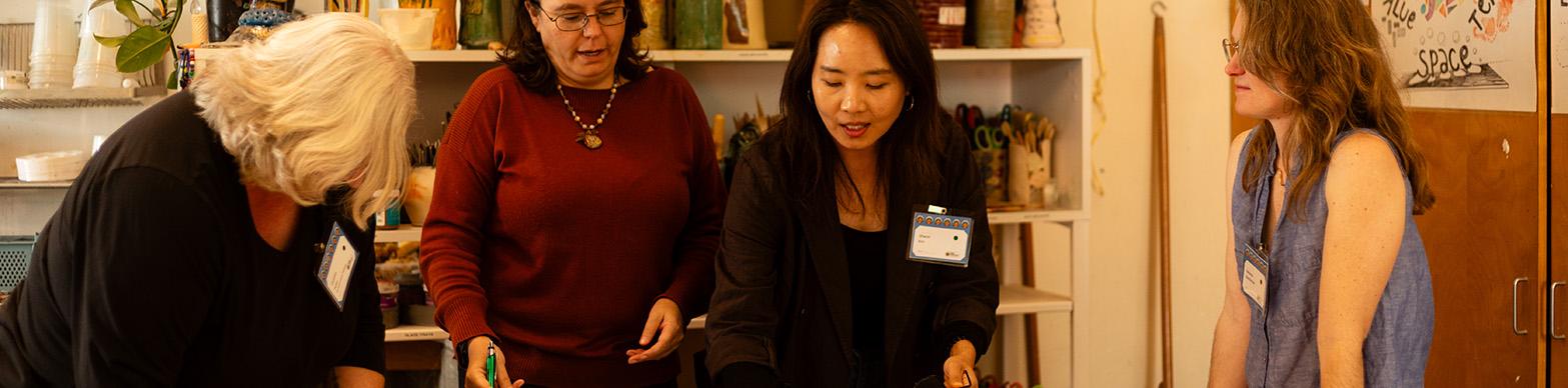 Five women pour over papers on a table