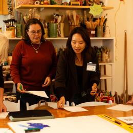Five women pour over papers on a table