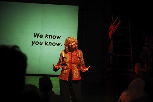 Woman standing in front of a projector screen teaching.